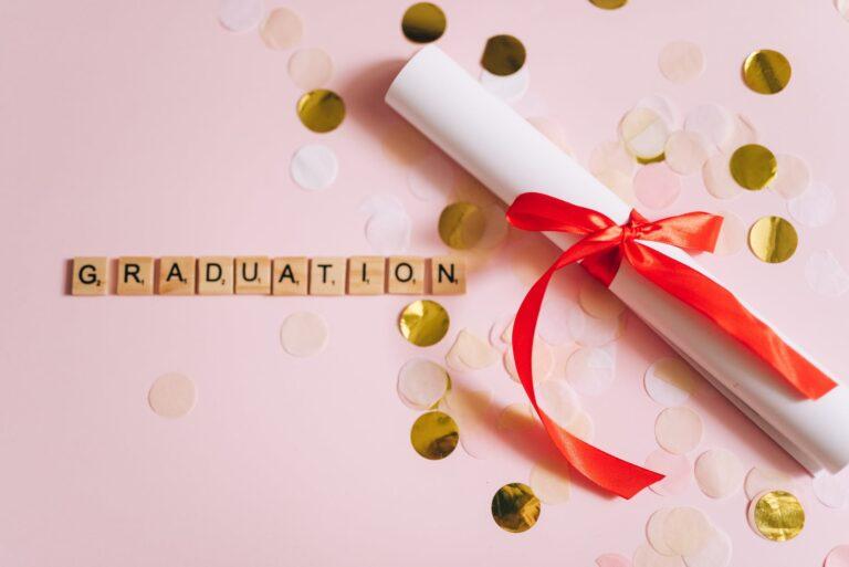 Psychic Tarot reader Maje Sodiz qualifications. From above, a picture of a paper diploma, tied up in a red bow. Next to it are gold sequence and a lettering that says graduation.